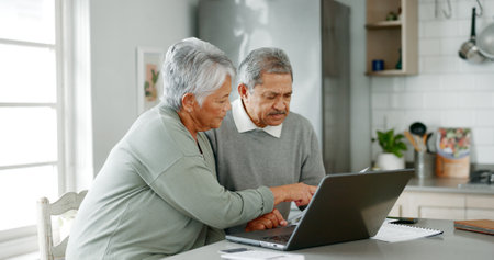 Senior couple, documents and finance with laptop for budget planning, retirement or pension fund at home. Mature, elderly man and woman with paperwork on computer for utility bill or mortgage expenseの写真素材