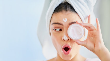 Funny face, moisturizer or woman in bathroom with beauty, glow or wellness with humor or joke. House, towel and girl with mock up space, cosmetics results or skincare cream with health and lotionの写真素材