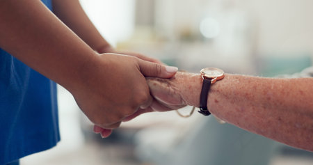 Holding hands, caregiver and senior patient for support, trust and care at nursing home. Closeup,...