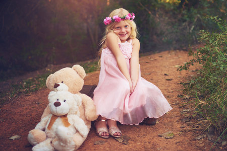 Happy, flower crown and portrait of child with teddy bear in nature for fantasy, imagination or play time in forest. Smile, plush toy and girl kid from Germany with floral headband outdoor in woods.の写真素材
