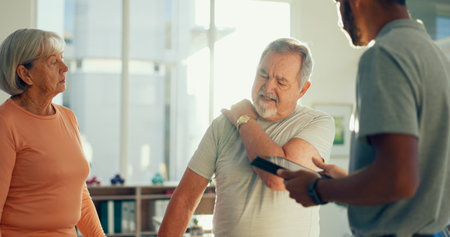 Physiotherapy, tablet and man with patient for shoulder pain for medical care, consulting and wellness. Healthcare, chiropractor and couple on digital tech for physical therapy, help or online reportの写真素材