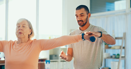 Weights, physiotherapy and man with senior woman for mobility, medical service and consulting. Healthcare, chiropractor and person with mature patient for rehabilitation, recovery and stretchingの写真素材