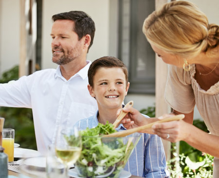 Food, dining table and green salad with vegetables, family and party with summer event, nutrition and ingredients. People, recipe and dish for lunch, eating and organic with cuisine, kid and gourmetの写真素材