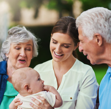 Mother, baby and grandparents talking in nature, trust and love in relationship connection. Mama, grandma and grandpa for outdoor child development, speaking and boy for bonding in childhood parkの写真素材