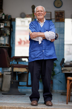 Barber shop, senior man and portrait with smile for beard trim, cutting and hair care for customer service. Small business, male owner and hairdresser in salon with scissors, tools and entrepreneurの写真素材