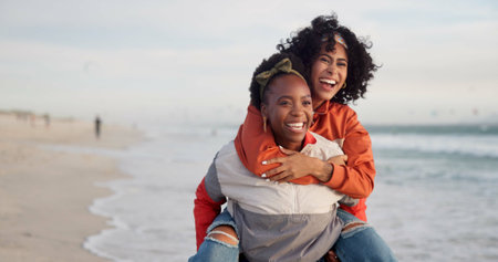 Friends, piggyback and smile with women on beach together for holiday, travel or vacation in summer. Love, support and trust with happy people having fun outdoor at ocean or sea for weekend bondingの写真素材