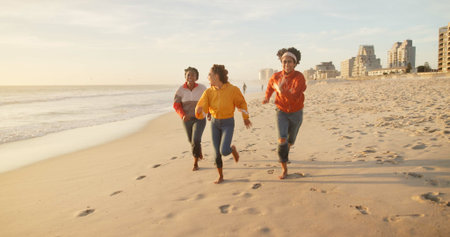 Friends, beach and running together on sand, outdoor freedom and weekend trip to ocean waves. Women,...