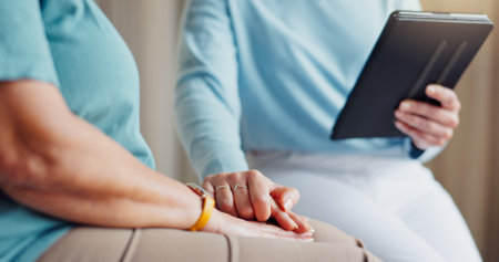 Tablet, holding hands and doctor with patient for empathy for medical service, diagnosis and online results. Healthcare, hospital and people on digital tech for wellness, comfort and compassionの写真素材
