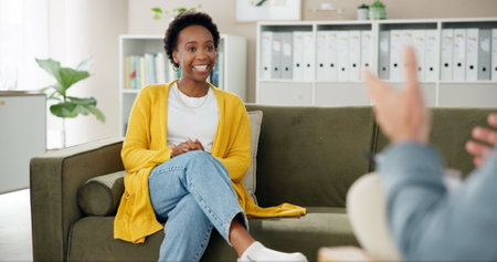 Psychology, therapist and woman on couch with smile, counseling and hope for anxiety management. Mental health, support or happy person on sofa with psychologist for consultation with stress reliefの写真素材