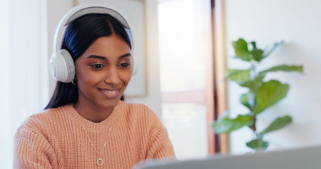 Indian woman, remote work and laptop with headphones for listening, hearing and editing online...
