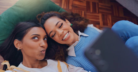 Pout, selfie and smile with couple of friends on floor of home living room from above for social media. Face, kiss and photograph with playful people in apartment for memory or profile pictureの写真素材