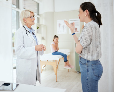 Doctor, woman and stress in office for healthcare, medical advice and professional opinion for child wellness. Pediatrician, mother or confused in consultation for kid recovery, diagnosis or questionの写真素材
