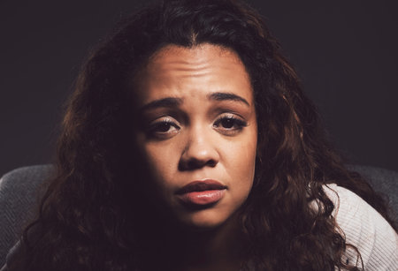 Crying, portrait and person with bipolar disorder in studio for mental health, psychology and ptsd...
