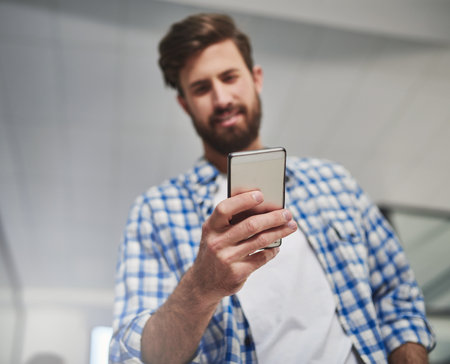 Phone, hand and business man reading email in startup for research, ads and check engagement info. Closeup, mobile and creative social media marketer design post for campaign on platform in low angleの写真素材