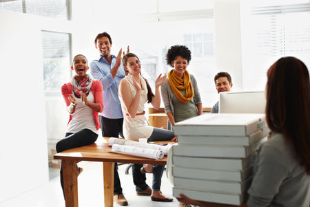 Excited, business people and applause with delivery for pizza, meal or lunch break together at office. Young, group or employees clapping with smile for food, boxes or dinner order at workplaceの写真素材