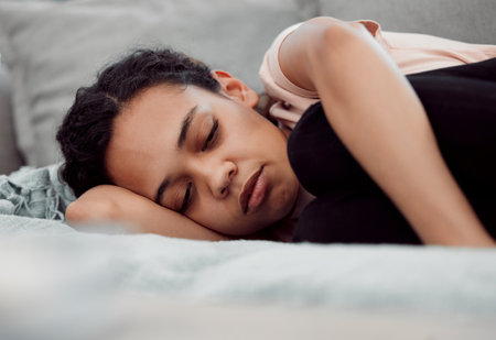 Woman, depression and sleeping for sad, mental health and trauma in house with insomnia, grief and loss. Girl, anxiety and fatigue for burnout, pain and broken heart in home with hopeless despairの写真素材