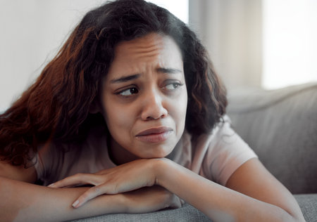 Woman, depression and crying for sad, mental health and trauma in house with insomnia, grief and loss. Female person, anxiety and fatigue for burnout, pain and broken heart in apartment with sorrowの写真素材