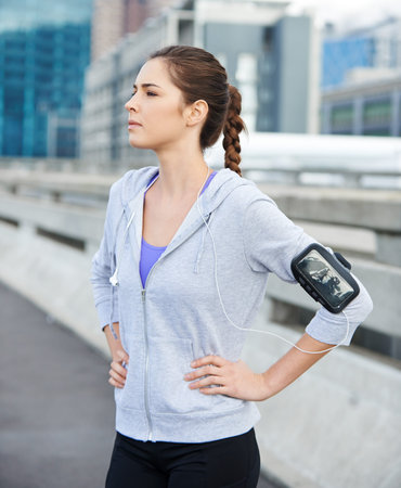 Thinking, earphones and woman in city for fitness, running or workout on bridge with music. Sports,...