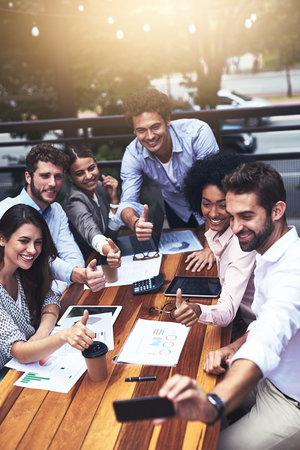 Teamwork, business people and smile with thumbs up for selfie, photography and agreement for...