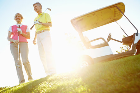 Sports, golf and mature couple in morning for game, match and competition on course, field and grass. Retirement, hobby and man and woman for activity, fun and practice to relax, bonding and playingの写真素材