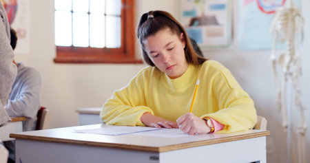 Writing, education and student in classroom for learning chemistry with notes for exam, test or project. Study, teenager and girl in lesson with books for science at school academy with scholarship.の写真素材