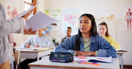 Girl, student or teacher with exam results, test or paper for moderation, examination or assessment at school. Young, female person or learner with document for academic evaluation or classroom scoreの写真素材