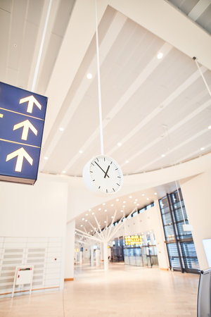 Airport, empty and waiting room with clock, hall and floor of terminal, lobby and architecture with detail. Design, interior and ceiling of building, abstract and space in business and corridorの写真素材