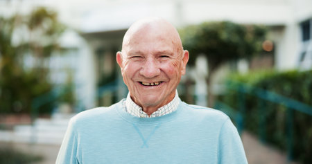 Portrait, smile and senior man at garden by nursing home for wellness, health or life insurance. Glasses, retirement and face of happy elderly person outdoor for relax, fresh air or confident in USAの写真素材