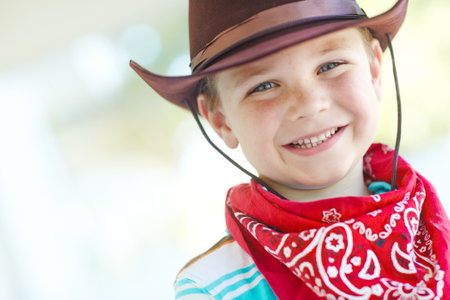 Happy, cowboy or kid in portrait in home, childhood and dress up for halloween concert with smile. House, child and fantasy theme with vintage fashion for character role, cosplay and pride in Texasの写真素材
