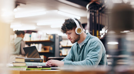 Man, student and typing on laptop in library for research information, university website and study...