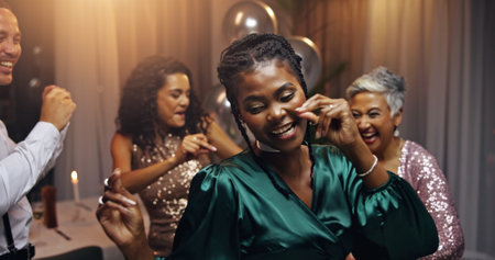 Woman, dancing and party at night, event and happy at new years eve with friends, diversity and colleagues. Business people, group and smile with snap, festive and excited with celebration at galaの写真素材