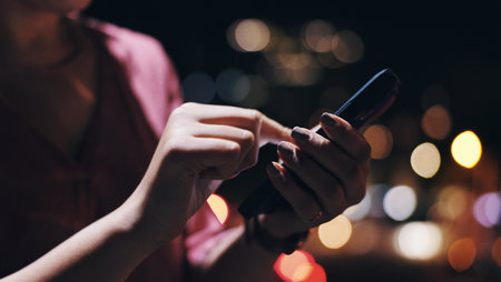 Night, phone and hands of businesswoman on rooftop of office building with research for investment. Tech, closeup and female financial planner typing email on cellphone for profit dividend report.の写真素材