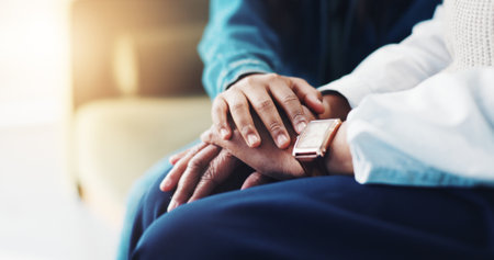 Support, child and holding hands with psychologist for care, faith or trust in clinic. Comfort, therapy or people together closeup for hope, empathy or help with mental health or depression diagnosisの写真素材