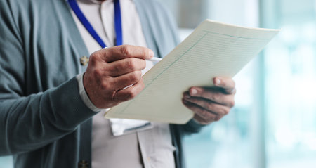 Hands, medical chart and reading with patient records in healthcare or examination as therapist. Doctor, man and folder for prognostic results, review or illness as psychologist in hospital or clinicの写真素材