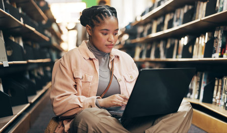 African, woman and student with laptop in library for research information, university news and...