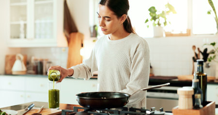 Woman, juice and cooking as chef for diet or recipe in home or kitchen with ingredients. Female person, frying pan and gourmet cuisine as creative or nutritionist for meal preparation, dinner or foodの写真素材