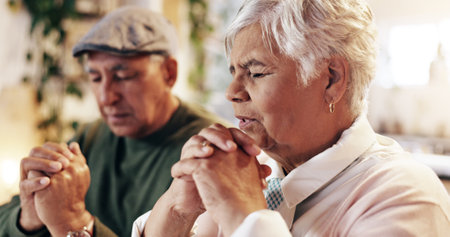 Retirement, praying and couple with faith, home and respect for God, worship and gratitude for holy spirit. Christian, old man and woman with praise to Jesus, talking and peace with belief and heavenの写真素材