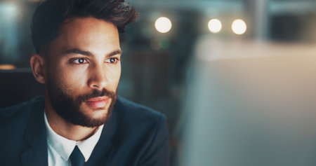 Night, thinking and man in office with computer, business plan and ideas for online project at digital agency. Research, overtime and businessman at desk checking email, report or review at startupの写真素材