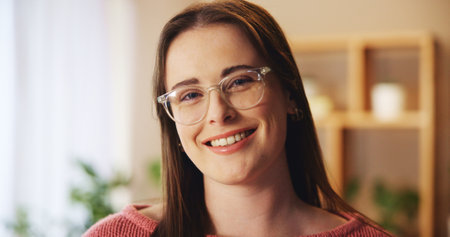Woman, portrait and smile with confidence in home for relax, weekend break and glasses in living room. Person, face and happy in lounge of apartment with pride, chilling and enjoyment with positivityの写真素材