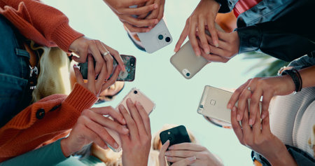 Phone, college and network with hands on campus for social media, gen z app and live streaming. Study, education and with low angle of people for news, connection and online university portalの写真素材