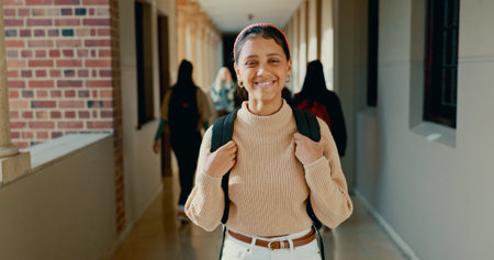 Smile, hallway and portrait of student at school with backpack for learning, studying or knowledge. Happy, teenager and girl from Mexico in corridor of academy for education class with scholarship.の写真素材