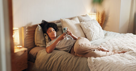 Woman, texting and phone on bed for social media surfing in home, typing message and notification....