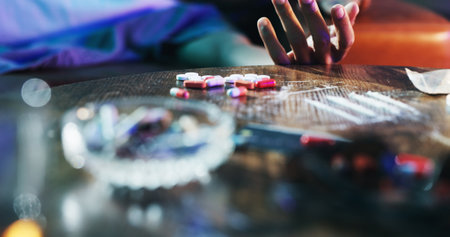 Person, hand and overdose in home with drugs, accident and medical emergency. Victim, narcotics and death in living room with addiction, help and substance abuse awareness with crisis or consequenceの写真素材