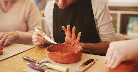 Pottery class, hands or people with clay sculpture for molding texture, manufacturing or art product. Closeup, workshop or creative artists learning in small business with hobby and craft projectの写真素材
