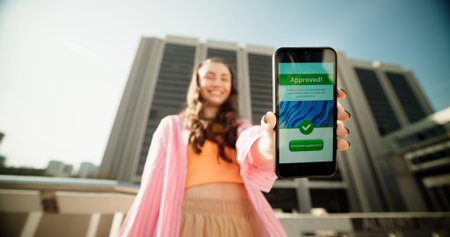 Portrait, screen and woman in city, smartphone and application with success, buildings and fashion. New York, face and happy person in street, girl and cellphone with message, digital app or approvalの写真素材