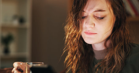 House, alcohol and sad woman with cellphone, depression and mental health with stress in lounge. Person, apartment or girl with smartphone, wine or grief with anxiety, loss or frustrated with messageの写真素材