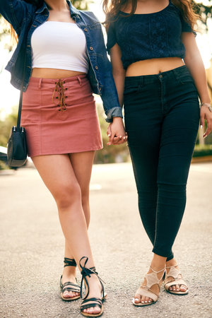 Women, lesbian or holding hands with legs of couple on road for walk, stroll or travel together in...