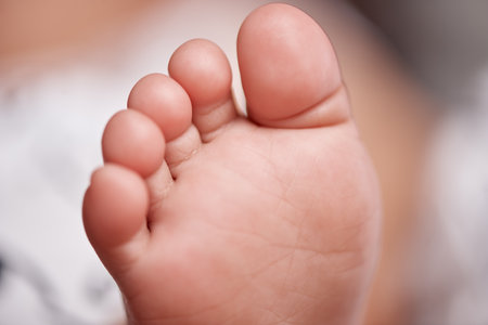 Nursery, bed and feet of baby in home for relax, resting and calm for sleeping or wake up in morning. Family, youth and closeup of newborn toes in bedroom for child development, cute and adorableの写真素材