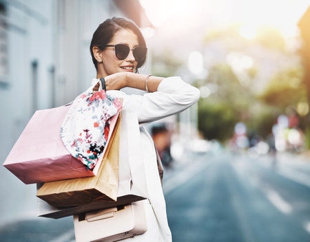 Portrait, shopping bag or woman on street walking on urban street for boutique retail sale or clothes. Sunglasses, smile or fashionable rich girl customer on city road smiling with luxury productsの写真素材