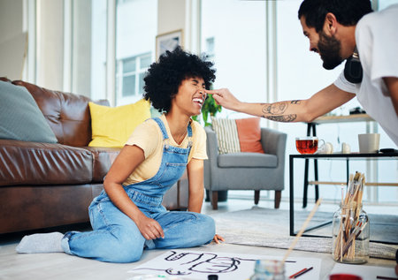Painting, playful and art with couple in living room of apartment for creative design, gallery and inspiration. Painter, color pallet and watercolor with people at home for drawing, canvas and hobbyの写真素材